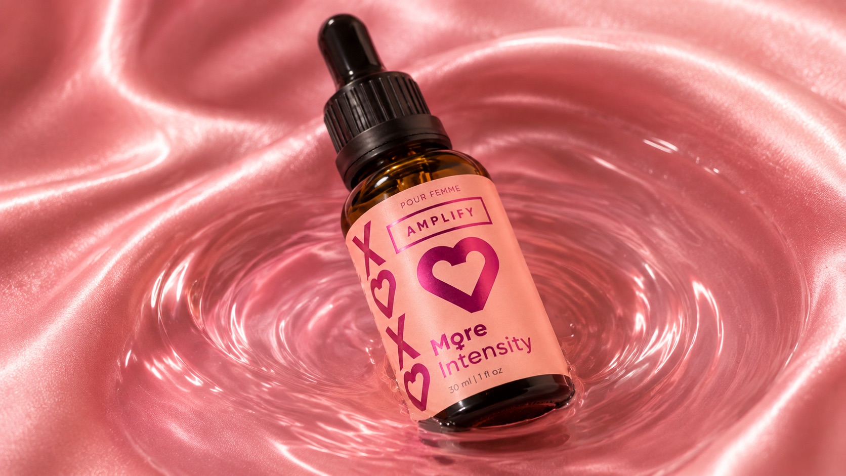 Amplify dropper bottle resting in rippling liquid on pink satin